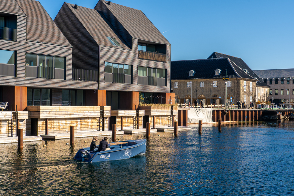 Copenhagen, un battello elettrico di GoBoat nel canale prospiciente Paper Island; sullo sfondo gli edifici dell’ex arsenale - foto di Andrea Forlani