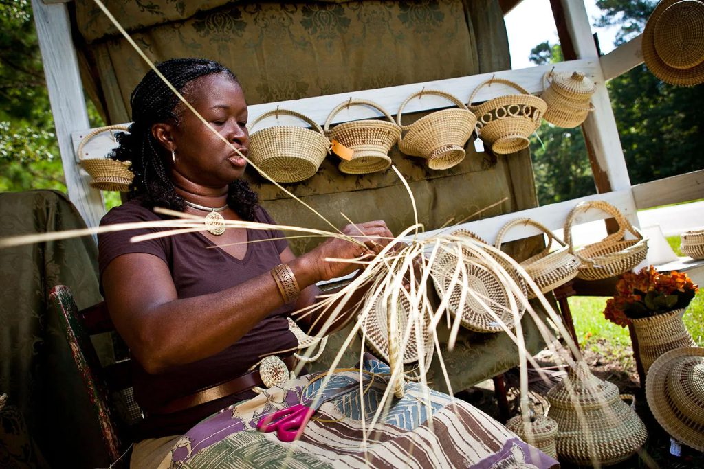 Una donna Gullah mentre intreccia cestini di vimini