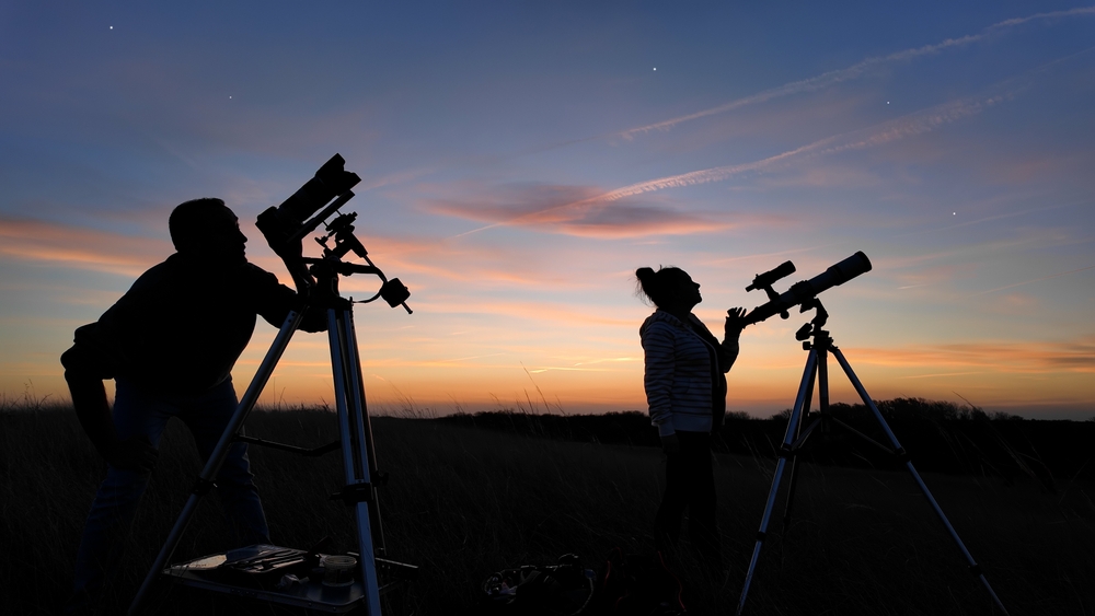 Cacciatori di stelle puntano i loro obiettivi durante un tramonto