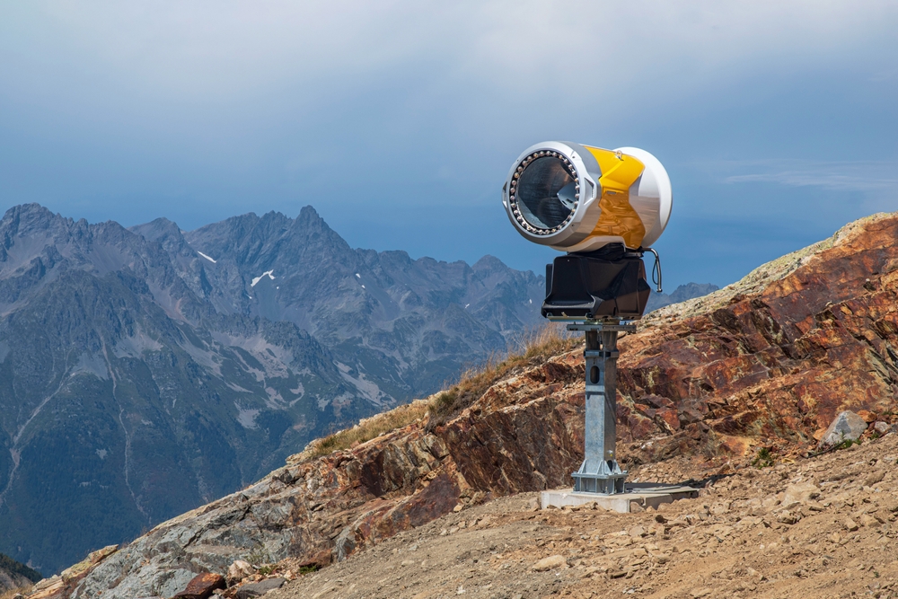 un cannone sparaneve installato su un pendio senza neve