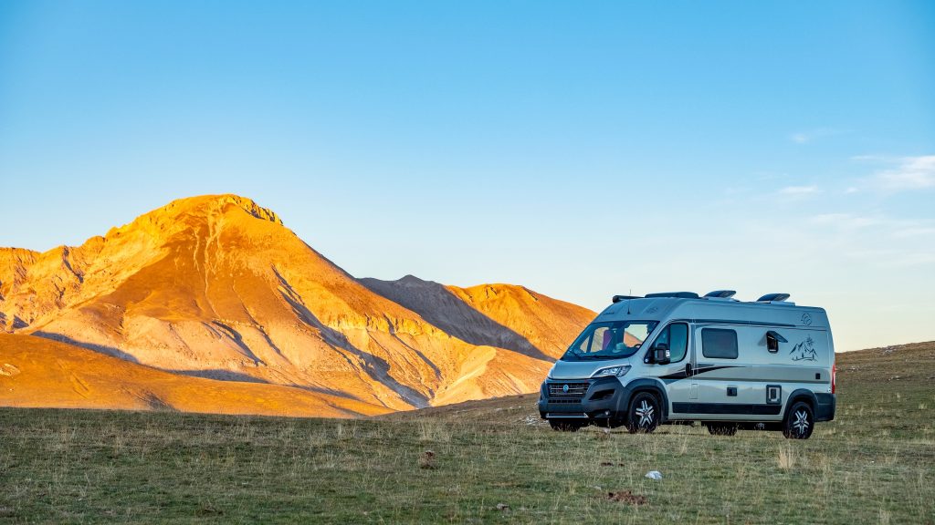 Un camper in un'area montuosa al tramonto