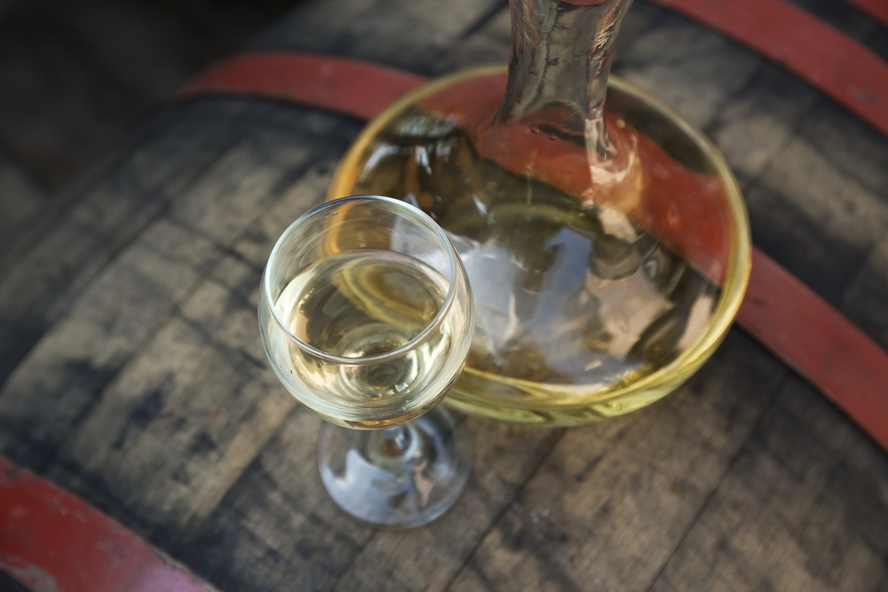 Un calice di vino bianco affianca un decanter