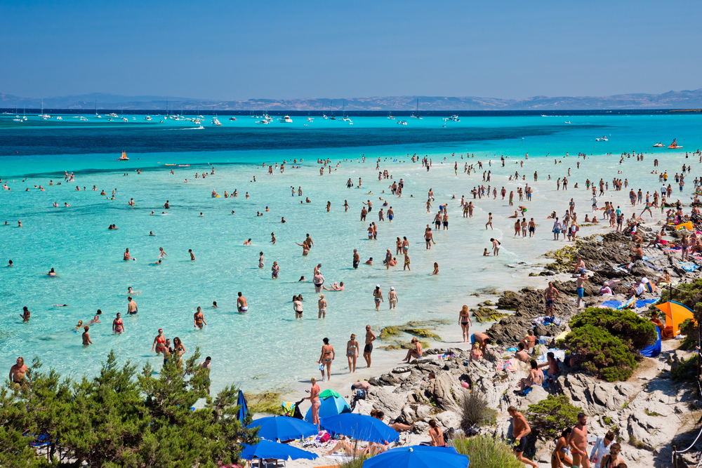 Moltissimi bagnanti si dividono tra spiaggia e l'acqua trasparente della spiaggia La Pelosa, a Stintino